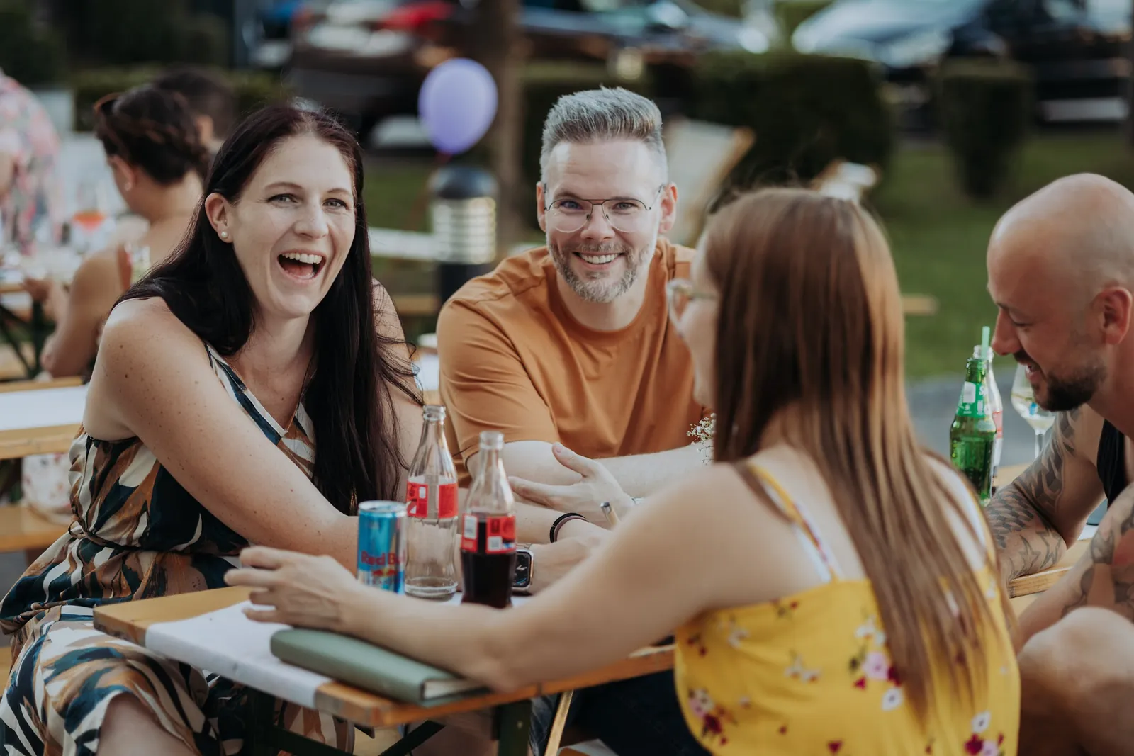 Lachende Runde an einem Tisch beim Sommerfest